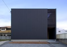 a black building with an open door in the middle of it's courtyard area