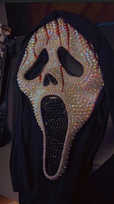 a black hoodie with a white mask on it's face and tongue sticking out