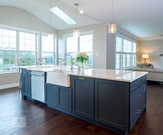 a large kitchen with an island in the middle and lots of windows on both sides