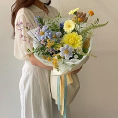 a woman holding a bouquet of flowers in her hands