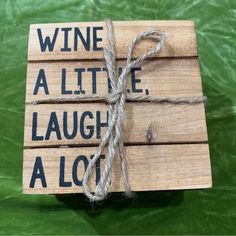 a wooden sign that says wine, all the laugh laughs at you with a string attached to it