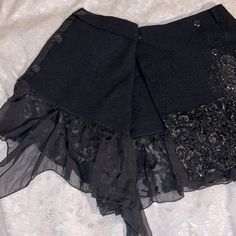 Blayde Italian Designer Unique Wrap Miniskirt Women’s Size 6/Medium (It 42) Wool With Black Sequins And Faux Tar(?) Embellishments Skirts By Blayde Typically Fit True To Size Brand New With Tags-Unworn, New/Nwt Msrp $665 Black 100% Wool Skirt Unlined Four Button Closure - 1 Interior, 3 At Edge Of Wrap Belt Loop Holes (Did Not Come With A Belt) Black Sequins And Beads Minimal Silver Thread As Accent With Beading. Tar- Looking, Shiny Material Painted Onto Skirt (I Know That Does Not Sound Appealin Gothic Asymmetrical Skirt For Party, Fitted Asymmetrical Skort For Party, Embellished Fitted Skirt, Gothic Flared Skirt Bottoms For Party, Gothic Ruffled Skirt For Party, Gothic Skirt Bottoms For Party, Gothic Fitted Bottoms With Ruffled Skirt, Fitted Gothic Asymmetrical Skirt, Black Embellished Mini Skirt