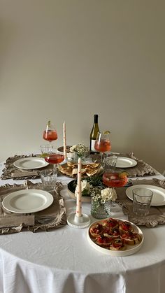 a table set with plates, glasses and wine bottles for an elegant dinner or brunch