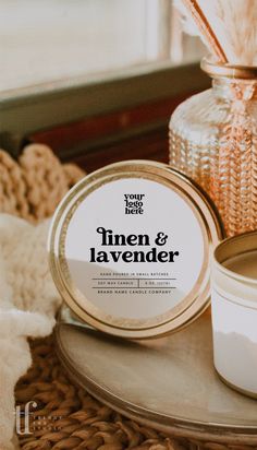 a candle and jar sitting on a table next to a basket with feathers in it