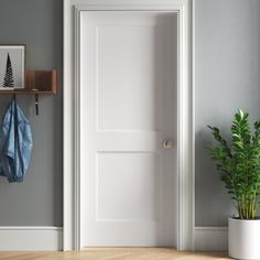 an empty room with a potted plant next to the door