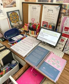 the desk is full of school supplies, including notebooks and pens with writing utensils on them