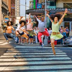 group of people jumping in the air on a city street