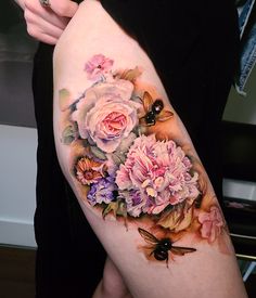 a woman's arm with flowers and butterflies on it