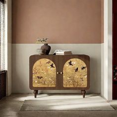 a cabinet in the corner of a room with a vase on top and birds painted on it