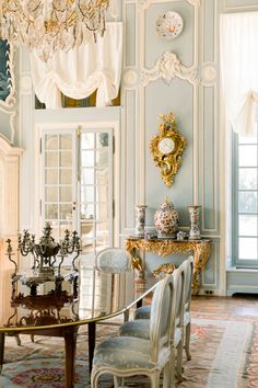 an elegant dining room with chandelier and chairs