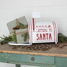 a mailbox with christmas decorations and presents on the top is sitting on a table