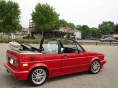 a red convertible car parked in a parking lot