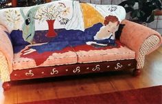 a couch covered in an artisticly designed painting on it's back and sides