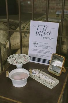 a table with some items on it and a sign in the background that says, tattoo station