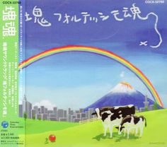 two cows are standing in the grass with a rainbow and city in the back ground