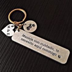 a keychain with two tags attached to it on a black surface that says, mama con cuado, te acc