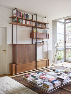 a living room filled with furniture and bookshelves next to a sliding glass door