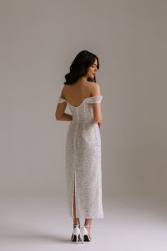 a woman in a white dress is looking back