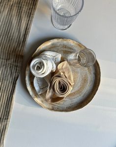 an empty plate with napkins and glasses on it