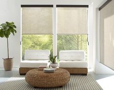 a living room with two couches and a coffee table in front of large windows