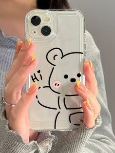 a woman holding up her phone case with a bear drawn on it