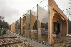 a building that has some glass on the side of it and is being constructed with wood