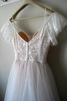 a white dress hanging up on a hanger