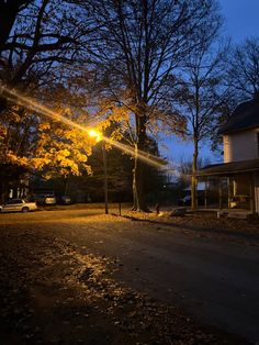 the street light shines brightly in front of a house on a dark night with no one around