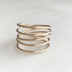 "This beautiful minimalist adjustable coil ring looks like stacked rings! Handmade by wire wrapping shiny, beautiful gold filled wire into an adjustable coil. Easily adjustable to any size finger. DETAILS *Color: Gold *Handmade from 20 gauge 14k gold filled wire sourced in the USA. *Wire wrapped and hammered for added strength. ADDITIONAL COLORS AVAILABLE Love these but want them in a different color? We have rose-gold and sterling silver coil rings available. Follow the link below to find your Gold Spiral Minimalist Stackable Rings, Minimalist 14k Gold Spiral Ring, Gold Spiral Stackable Rings, Minimalist 14k Gold Wire Wrapped Rings, Gold Minimalist Wire Wrapped Midi Rings, Minimalist Rose Gold Wire Wrapped Ring, Gold Wire Wrapped Minimalist Midi Rings, Minimalist Wire Wrapped Yellow Gold Ring, Minimalist Wire Wrapped Rose Gold Ring