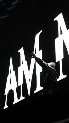 a man standing on top of a stage with his arms in the air