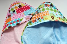 two baby bibs laying on top of each other