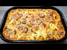 a casserole dish with cheese and mushrooms in it sitting on a table top