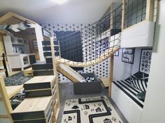 a room with black and white wallpaper, rugs, shelves, and slides