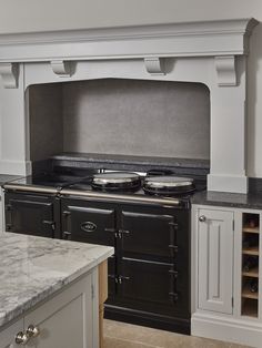 an old fashioned stove with two pots on it's burners in a kitchen