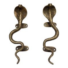 two antique style door handles with decorative designs on each handle and one has a snake design