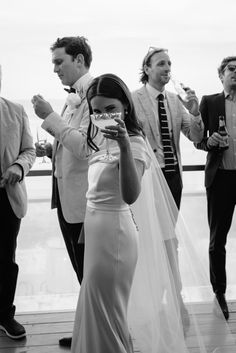 a woman in a wedding dress standing next to other people