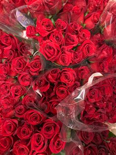 a large bouquet of red roses is wrapped in plastic