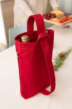 a red bag sitting on top of a white table next to a tray with food