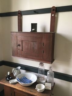 an old wooden cabinet with dishes on it