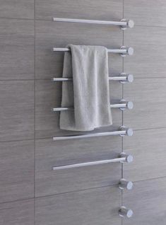 a towel rack with three towels hanging on it's sides and two metal bars attached to the wall