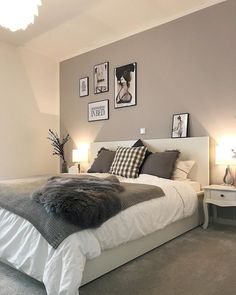 a bedroom with grey walls and pictures on the wall