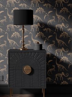 a black and gold dinosaur wallpaper with a lamp on it's side table