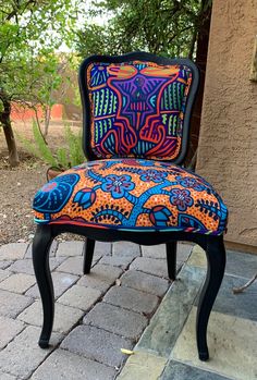 an upholstered chair sitting on top of a brick patio