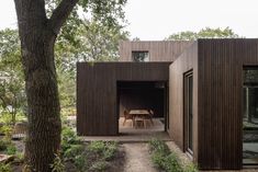 the house is surrounded by trees and has an open door that leads to another room