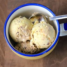 two scoops of ice cream in a blue and white bowl on a wooden table