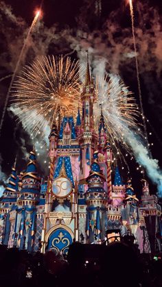 fireworks light up the night sky above an illuminated castle at disneyland's magic kingdom