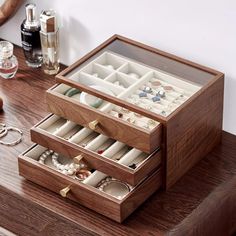 an open wooden jewelry box sitting on top of a table