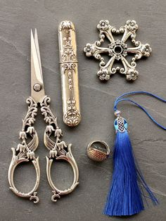 three pairs of scissors, one with a tassel and the other with a key chain