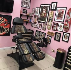 a salon with pink walls and lots of pictures on the wall, including an animal print reclining chair