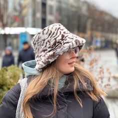 Tiger print bucket hat made of faux fur. The fur is not prickly but very soft and pleasant to the touch. The hat has a fleece lining, making it very warm, so it's a perfect solution for the cold, windy winter in the city. 👌 SIZE: 📐 One universal size. It fits for sizes between 20.5 - 23 in. (52 - 58 cm) (XS - L)! SEND AS GIFT: 🎁 If you need gift box and gift message, you can select them in your shopping cart at checkout. EXPRESS SHIPPING: 🚀 ❗ FOR EXPRESS AND INTERNATIONAL DELIVERY, PLEASE, ADD YOUR PHONE NUMBER IN A NOTE TO YOUR ORDER! USA - FedEx within 2 days and overnight - 1 day. WORLDWIDE - DHL within 2-5 days. Select shipping upgrade at checkout in your cart. Winter Bucket Hat With Faux Fur Lining, Blonde Wearing A Cow Print Faux Fur Bucket Hat, Faux Fur Lined Brimmed Bucket Hat, Winter Pink Bucket Hat, One Size, Fur Bucket Hat, Faux Fur Bucket Hat, Custom Gift Wrapping, Hooded Scarf, Tiger Print